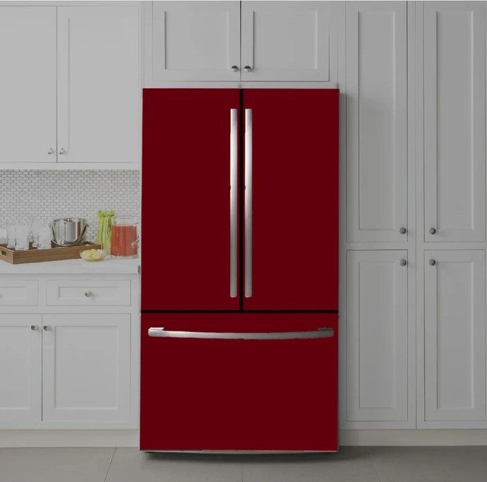 Modern kitchen with a red French door refrigerator surrounded by white cabinets and a countertop with small appliances.